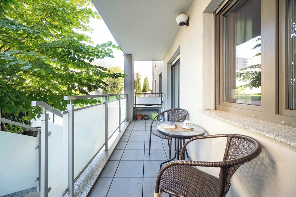 Furnished balcony with green surroundings.