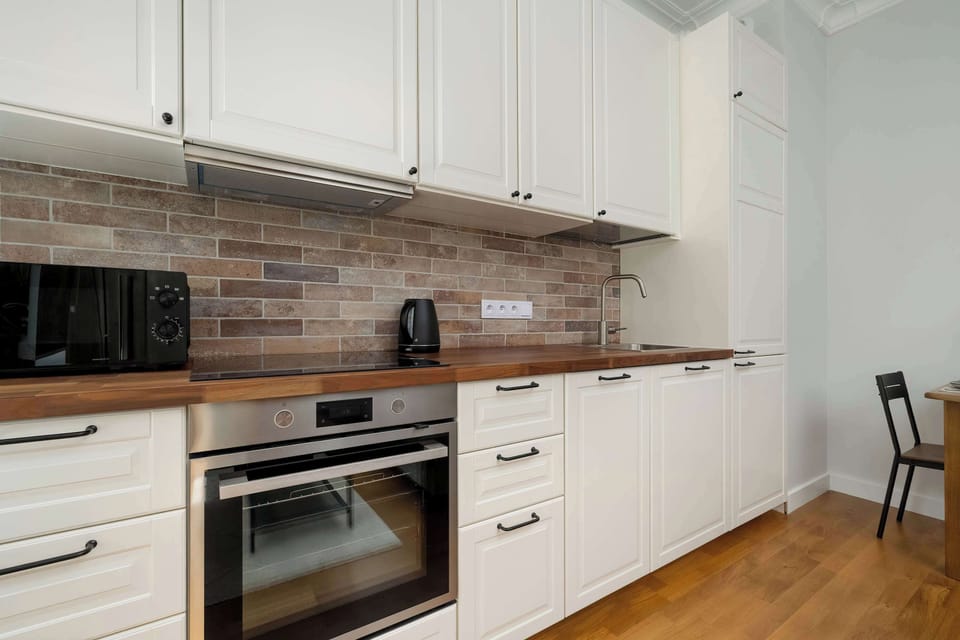 A kitchen view opening to the bathroom, revealing white walls, warm wood tones, and cohesive design elements throughout.