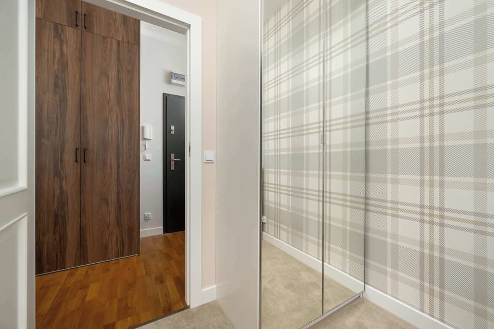A closer look at the entryway and wardrobe area with a wood-finish door and patterned walls for a clean, stylish entrance.