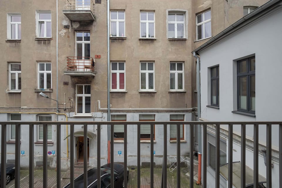 A balcony overlooking a residential area with buildings and a calm atmosphere.