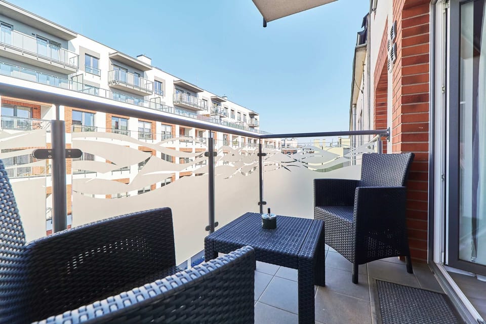  Balcony with outdoor seating and a view of a street, perfect for relaxing in the fresh air.