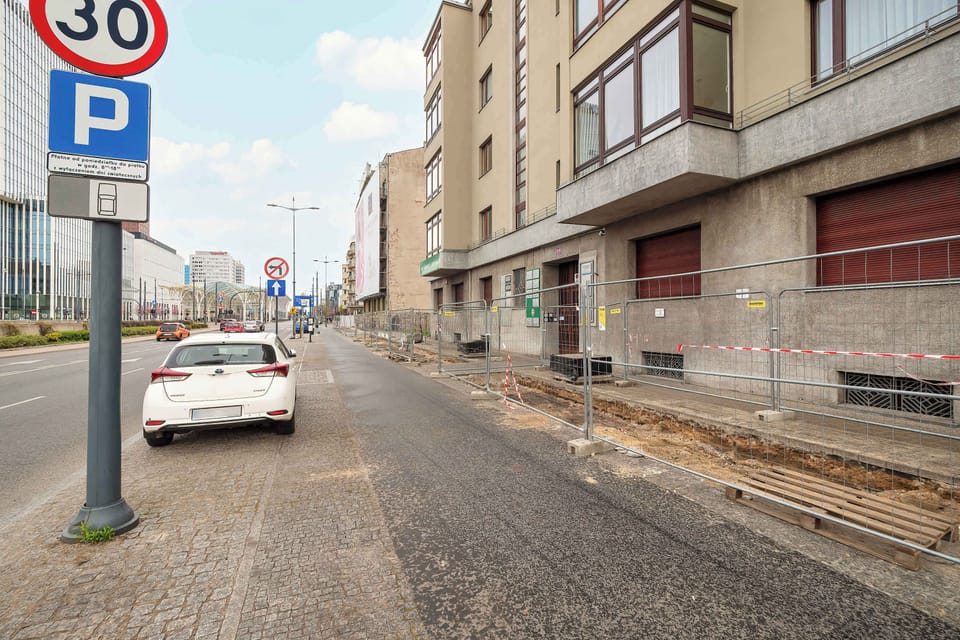Street view of the building and the cobblestone road in front.