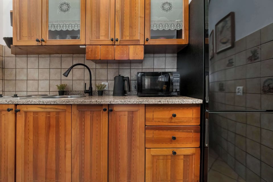Kitchen area with wooden cabinets, a stove, a microwave, and essential appliances.