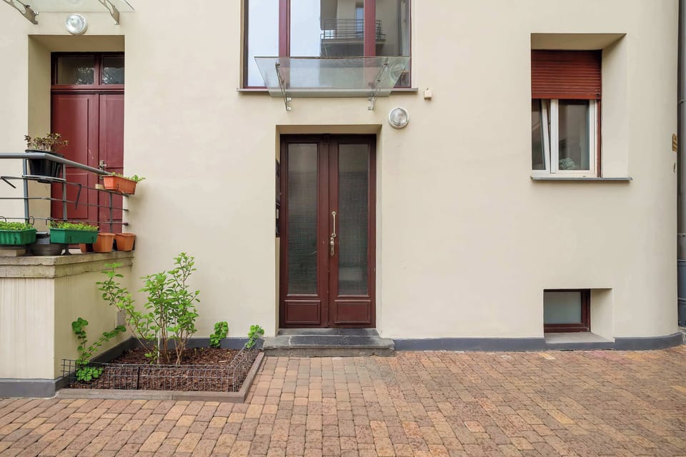 Building entrance seen from outside with a small garden.