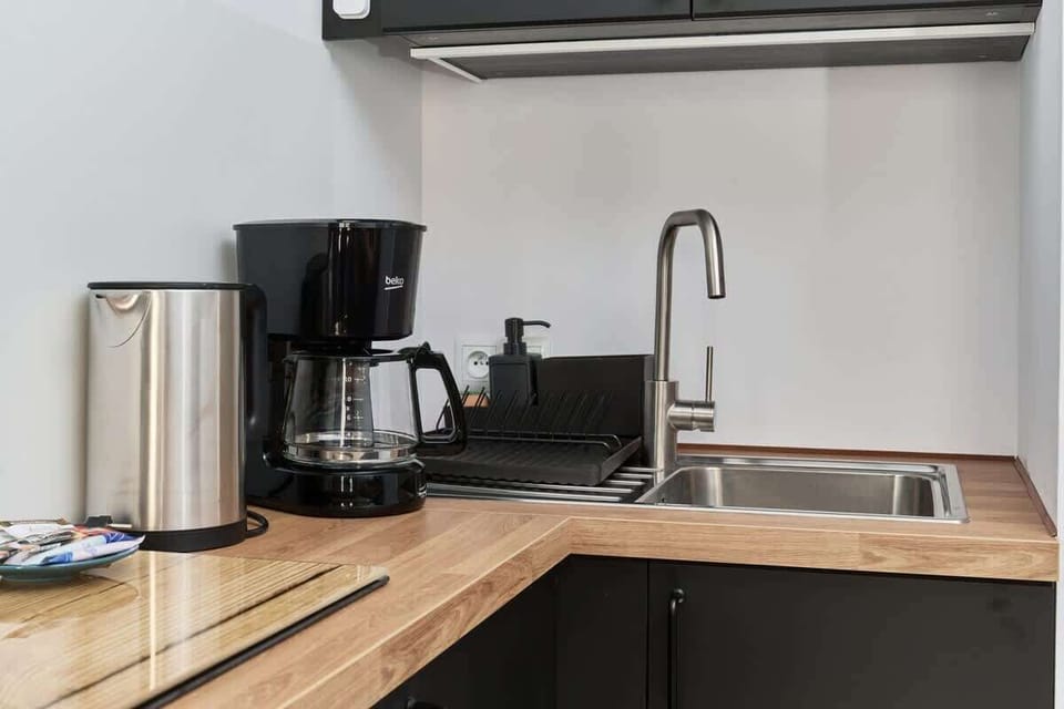 A close-up of the kitchen showing the kettle, coffee maker, and a simple, organized countertop.