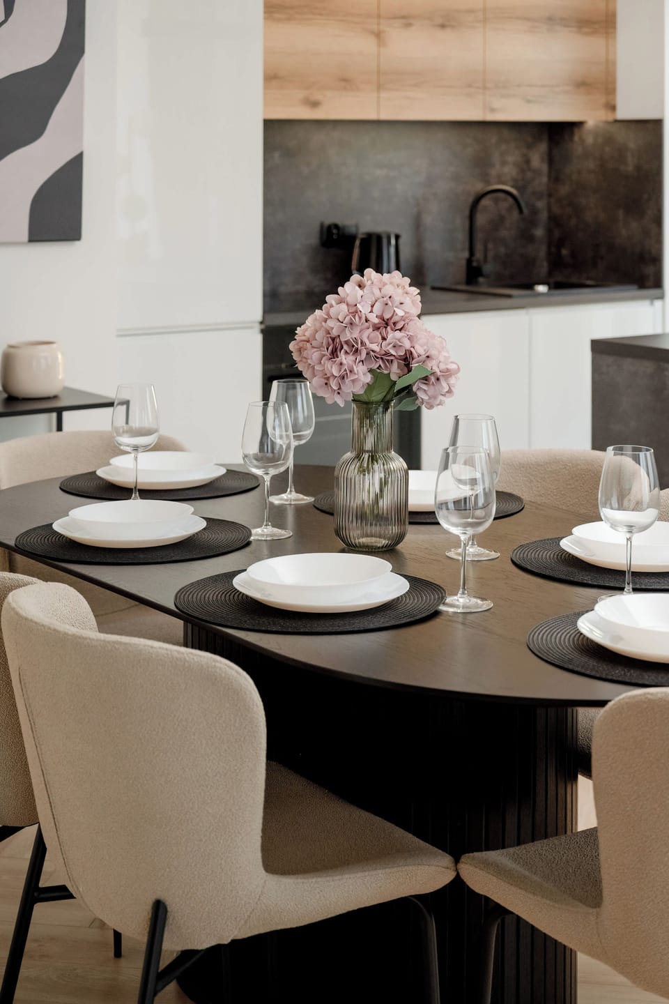 A close-up of the dining table, set for six, with a modern design. The tableware is stylish, giving the room a sophisticated dining atmosphere.