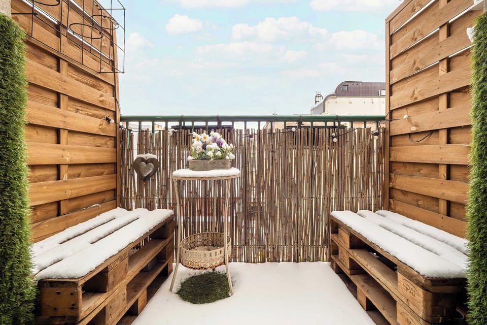 Spacious balcony with outdoor furniture. 