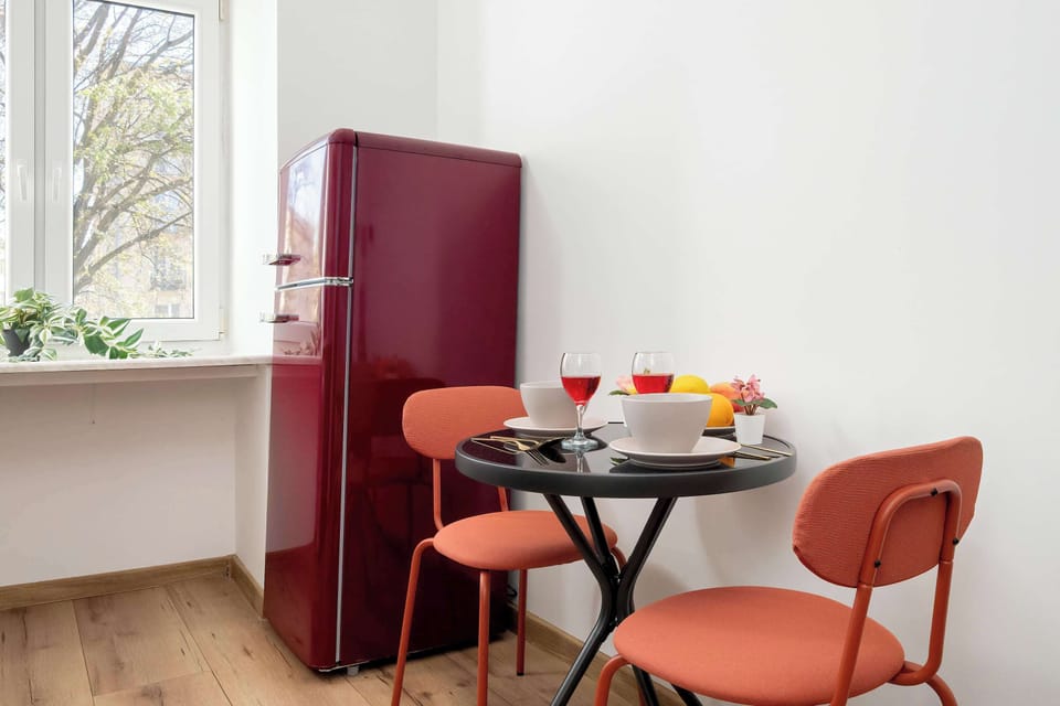 A small table and two velvet chairs by the window create the perfect spot for morning coffee or an evening chat.