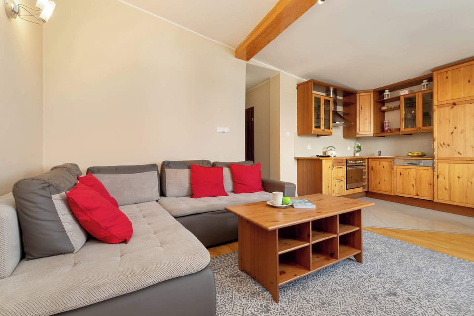 A cozy and stylish living area with exposed wooden beams, a dining space, and a seating area, creating a warm and inviting atmosphere.
