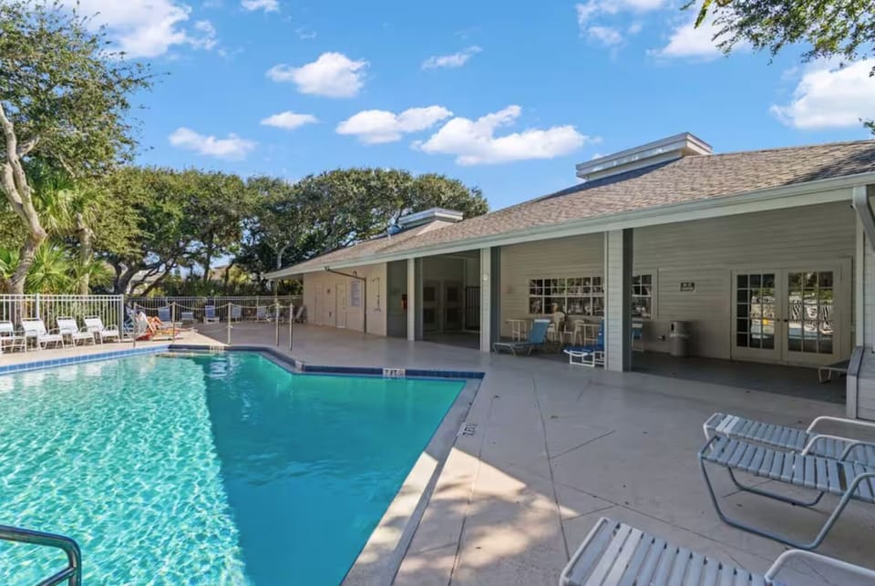 Resort-style pool with shaded seating and clubhouse amenities

