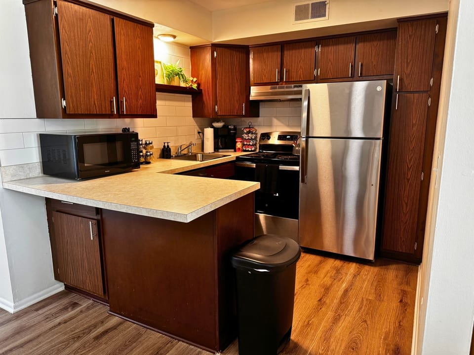 Fully equipped kitchen with stainless steel appliances and bar seating.