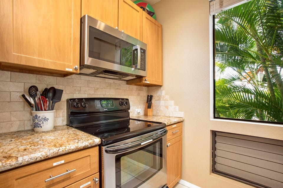 Modern kitchen with full-size appliances and tropical window view