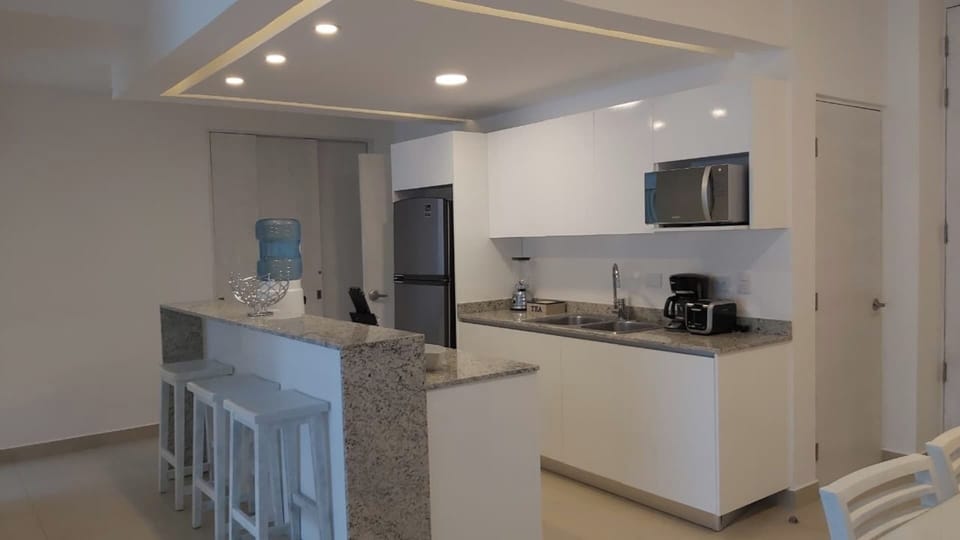 Cocina equipada con microondas, cafetera, refrigerador, estufa, cuchillos cucharas, ollas, licuadora y dispensador de agua.

Kitchen equipped with microwave, coffee maker, refrigerator, stove, knives, spoons, pots, blender and water dispenser.