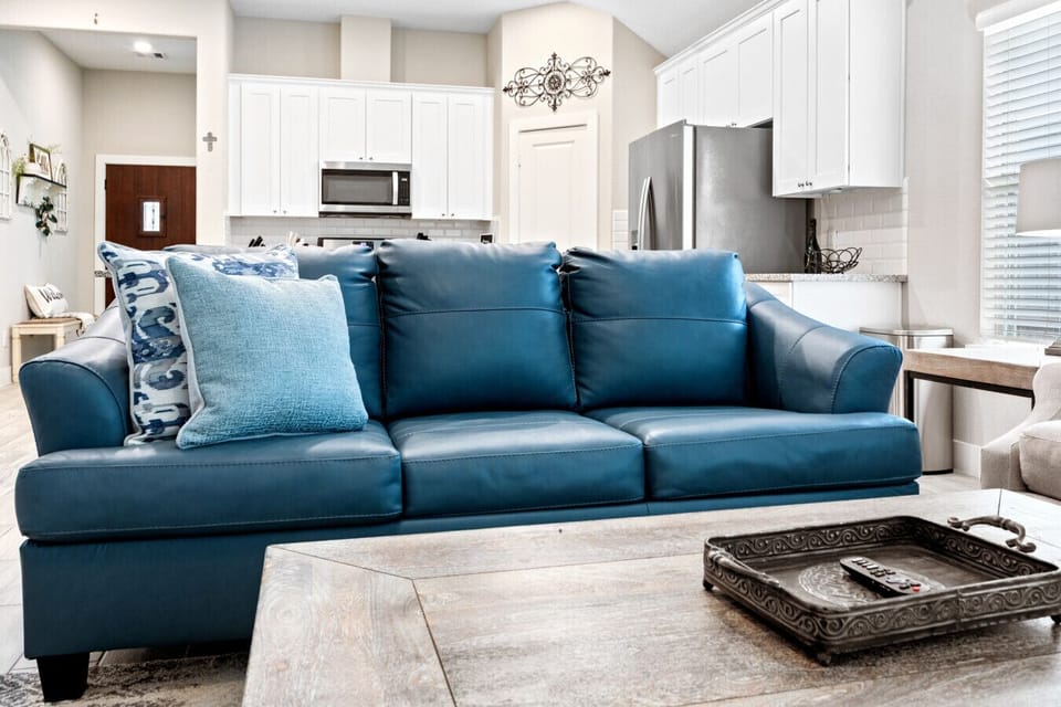 Stylish blue leather sofa adds a pop of color and comfort to the open living space.