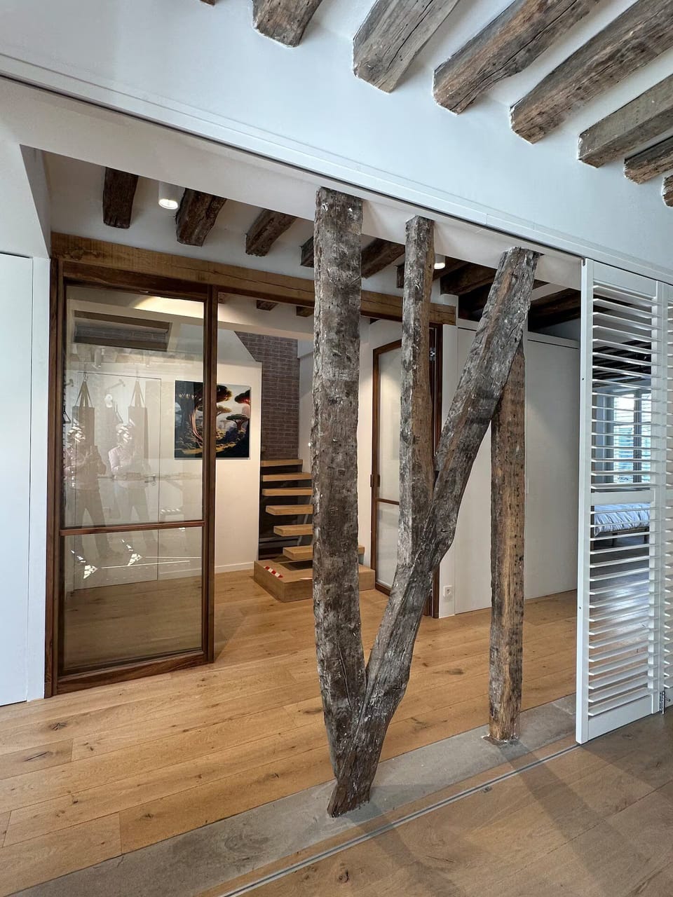 At stairs base: Bathroom 2 left; gym access right, closed by sliding wood panels