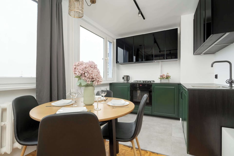 Functional dining area situated next to the elegant green kitchenette.