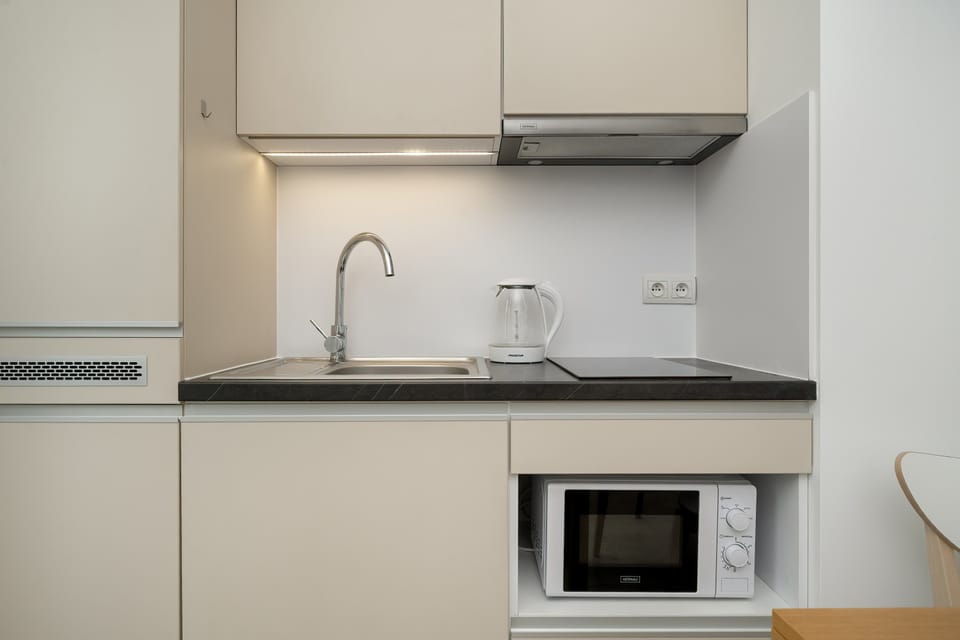 A functional kitchenette with microwave, fridge and induction hob allows you to prepare home-cooked meals.