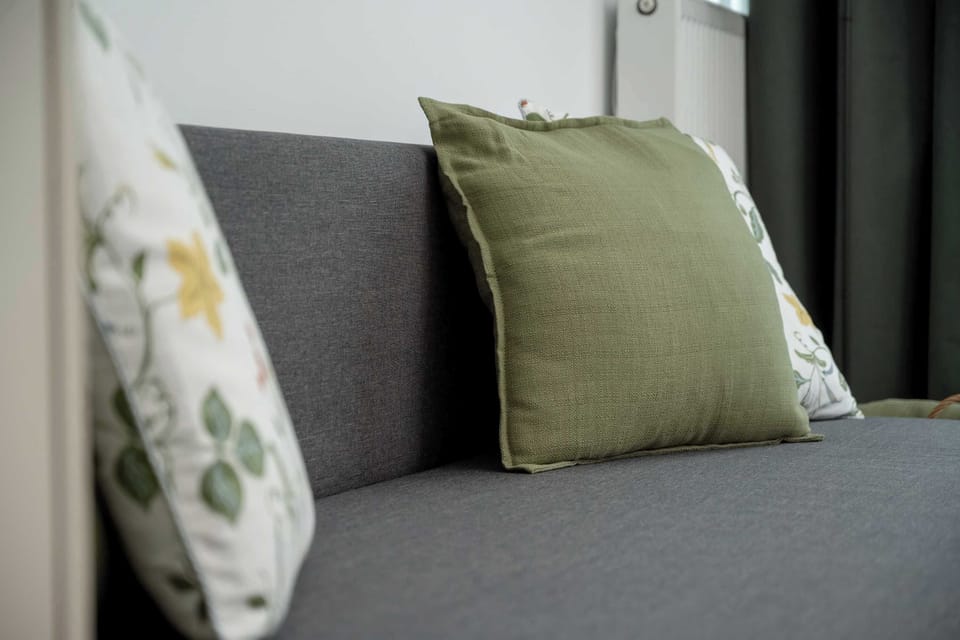 Close-up of decorative cushions lying on a grey sofa.