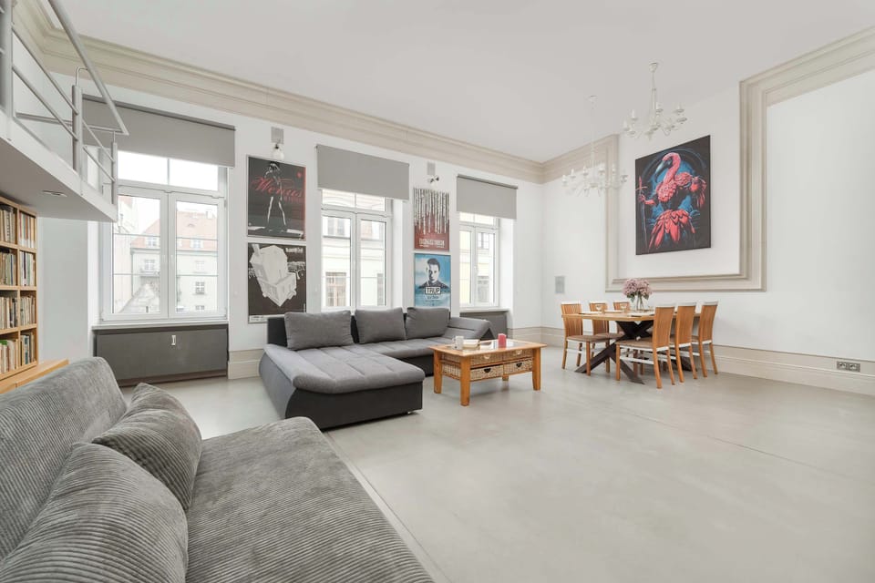 A spacious and bright living room with a cozy gray sofa, a large bookshelf, and a stylish coffee table, perfect for relaxation.