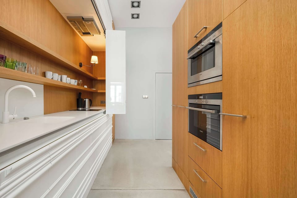 A stylish and functional kitchen with warm wooden tones. The open layout connects seamlessly to the rest of the apartment.