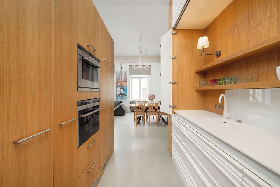 A sleek and modern kitchen with wooden cabinetry and built-in appliances. The clean design enhances functionality and aesthetics.