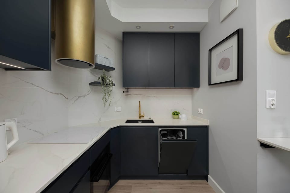 A compact, modern kitchen with dark cabinets, built-in appliances, and a breakfast bar for quick meals.