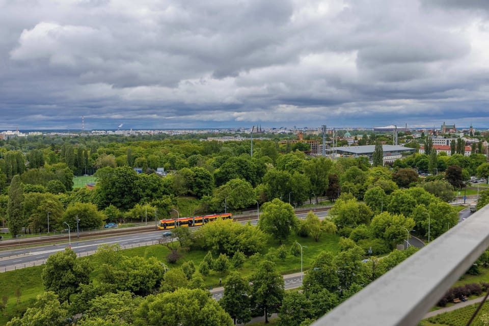 Another cityscape view from above, showing green trees and residential buildings. The perspective showcases the peaceful surroundings.