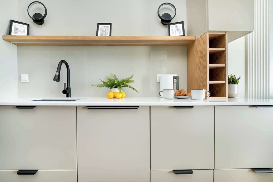 Functional and bright kitchenette with modern equipment such as a kettle, an oven, a fridge and a dishwasher.