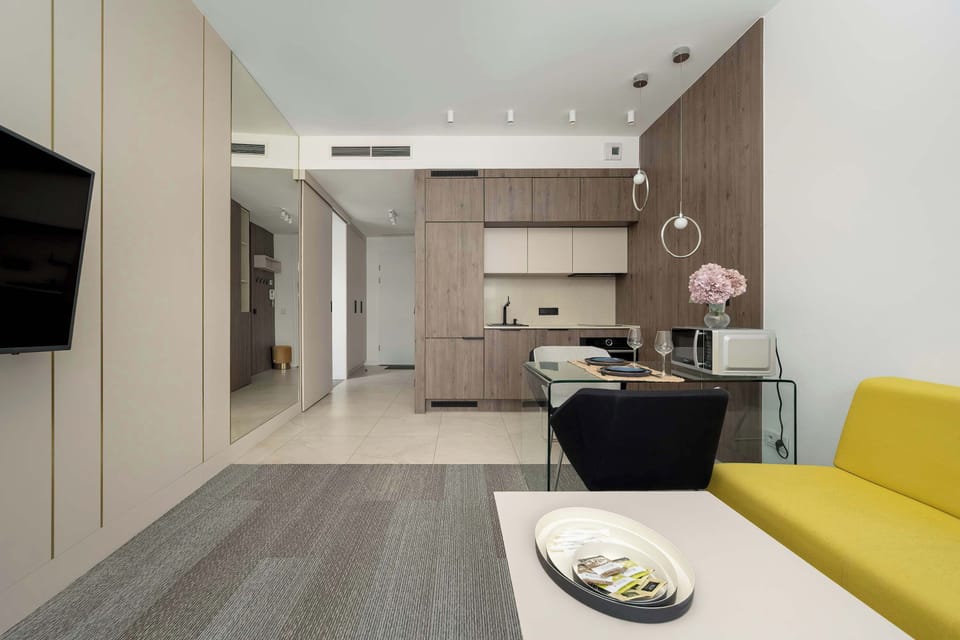 An open-plan living space with a sectional sofa and large windows leading to a balcony.
