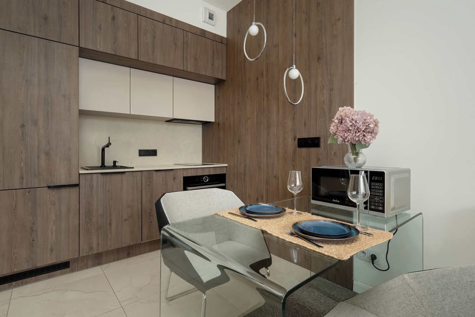 A view of the kitchen and dining area with wood cabinetry, modern appliances, and a clean layout.

