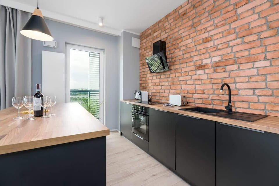 Another perspective of the kitchen, focusing on the induction cooktop and stylish wooden counter space.