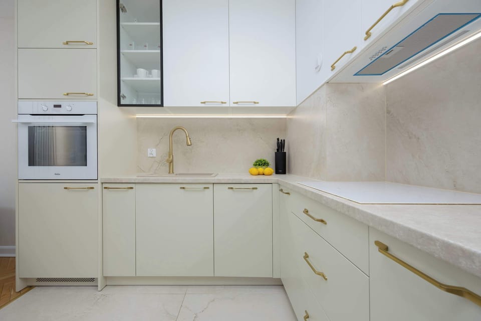 Elegant kitchen with bright cabinets, cooker, oven and modern finishes.