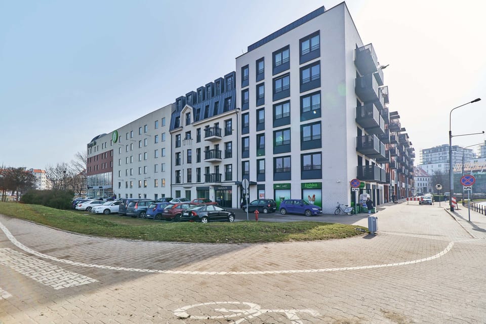 Exterior view of an apartment building surrounded by clean pathways and a well-maintained environment.