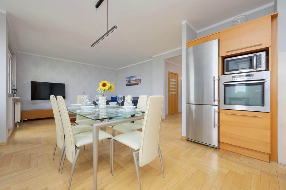 Another angle of the same open-plan area, showcasing the blue armchairs and a kitchen island.