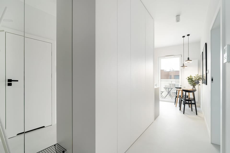 A bright hallway featuring sleek built-in wardrobes and modern lighting.