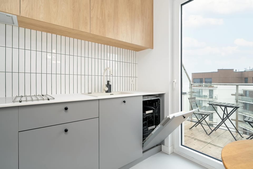 Functional kitchen with grey cabinets and high quality appliances to ensure home-cooked meals can be prepared. From the kitchen there is access to the balcony.