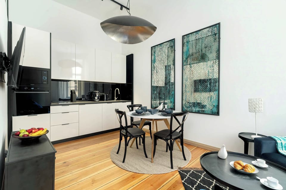 A functional kitchen with white furniture and a dining area creates a harmonious and stylish combination.