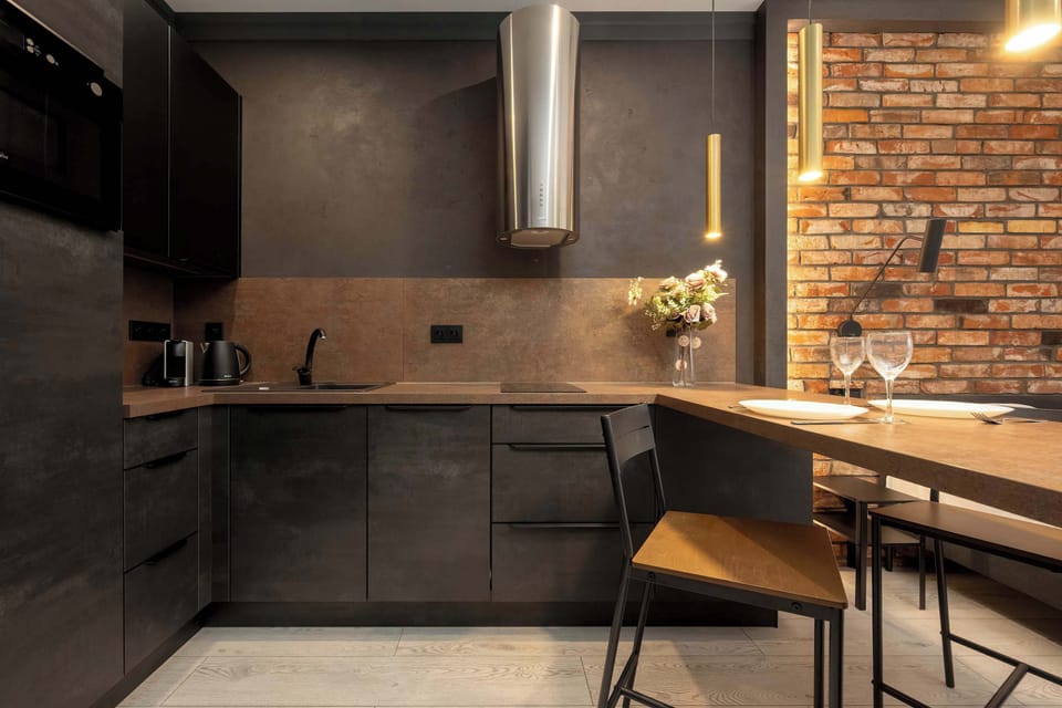 The kitchenette with black cabinetry and wooden accents combines modern design with a cozy vibe.