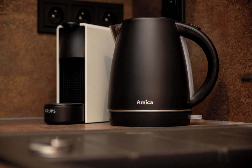 The coffee maker and kettle are ready for your morning ritual, ensuring each day starts in comfort.