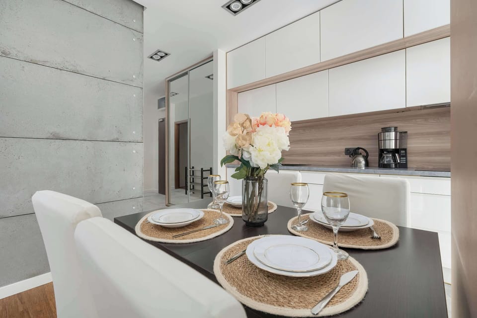 The dining room is elegant and functional, with a round table for four decorated with flowers in the centerpiece.