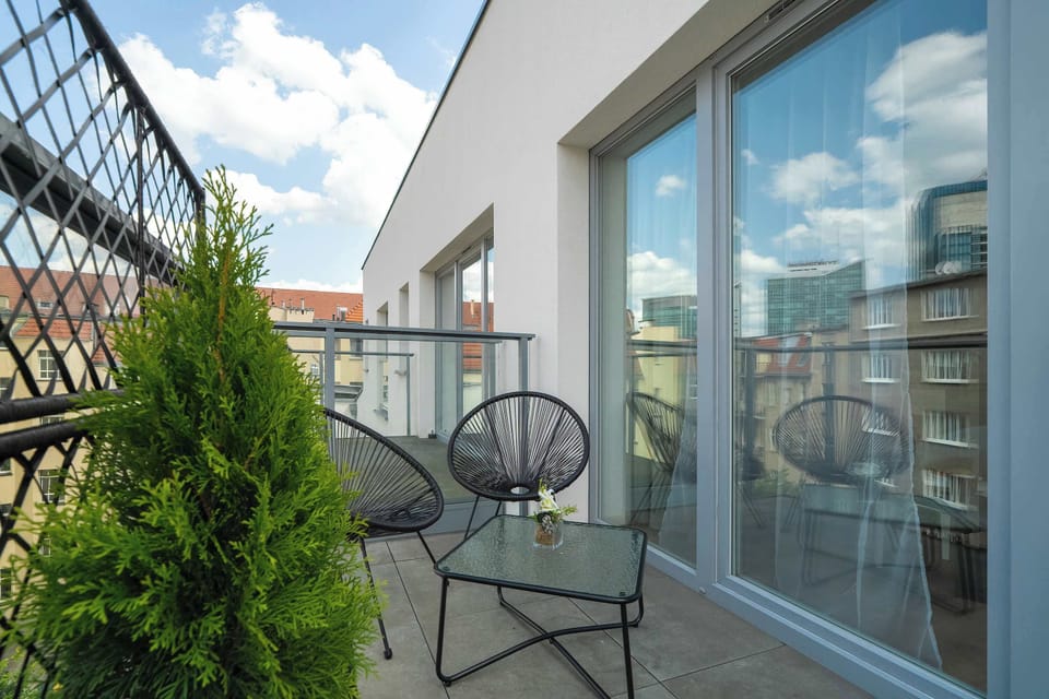 A green balcony overlooking rooftops and sky invites moments of relaxation any time of day.

