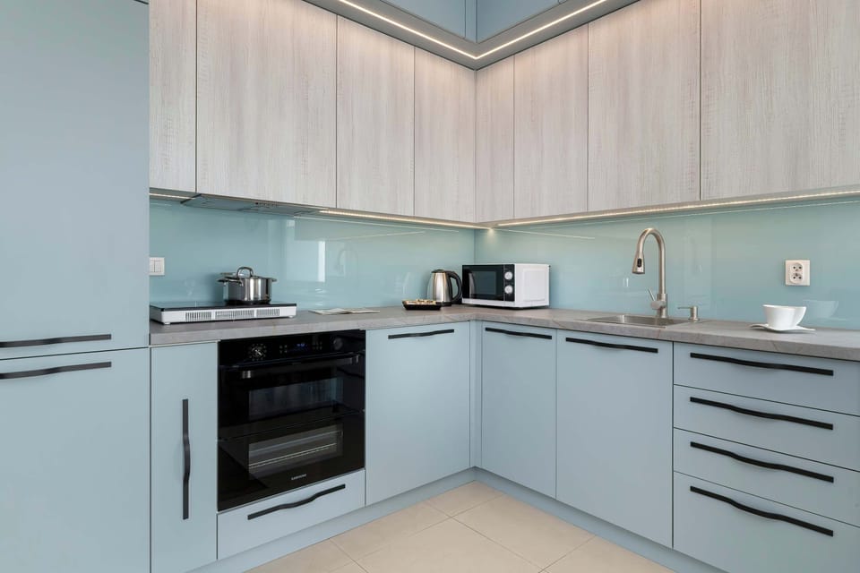 A sleek kitchen with light wood cabinets and built-in appliances.