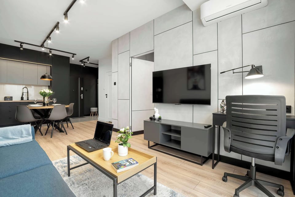 Living room with double sofa bed, Smart TV and remote work area.