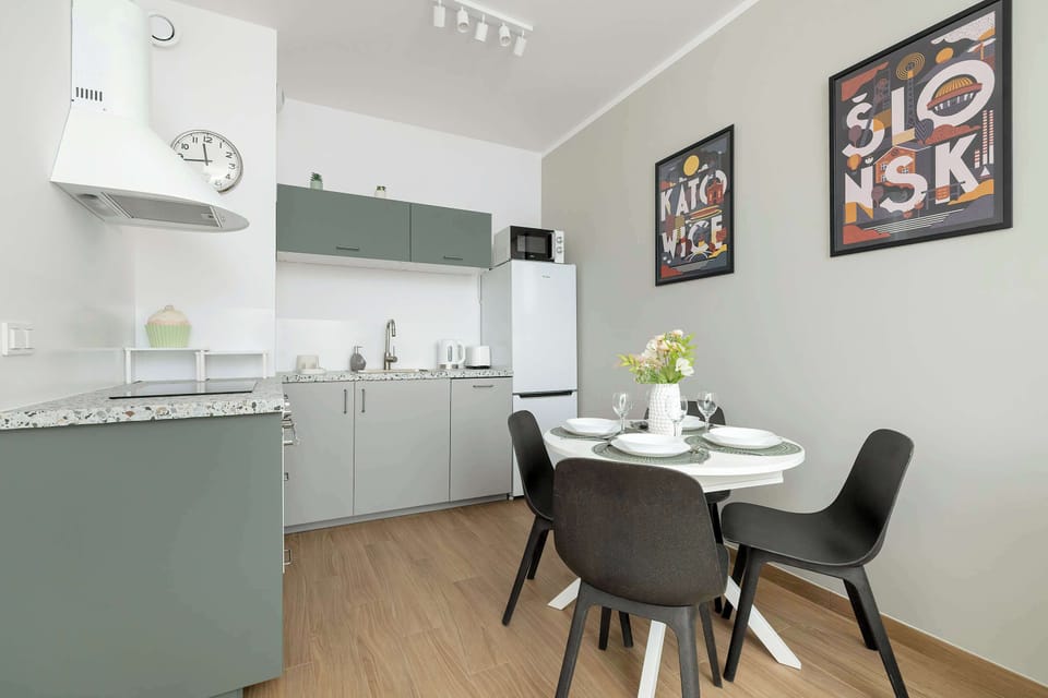 A well-designed kitchen with gray cabinets and a small dining table, offering functionality and a clean aesthetic.