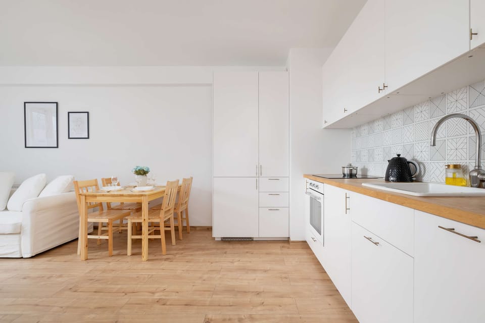 Living room with a fold-out sofa bed, dining area and kitchenette.
