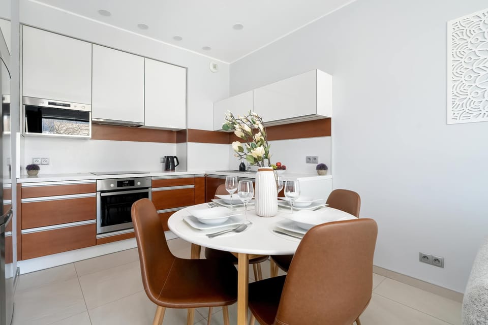 Fully equipped kitchenette with induction cooktop, oven, microwave, electric kettle, refrigerator with freezer, dishwasher and dining area.
