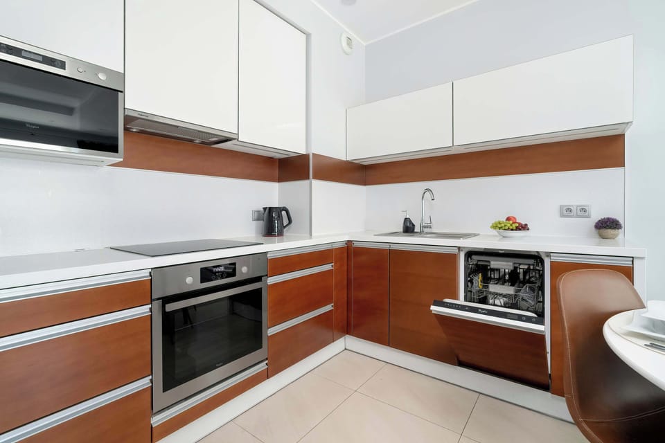 Fully equipped kitchenette with induction cooktop, oven, microwave, electric kettle, refrigerator with freezer and dishwasher.