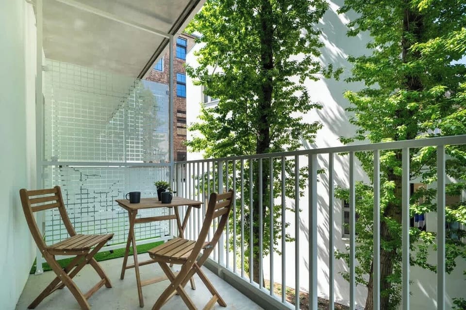 Furnished balcony with green surroundings. 