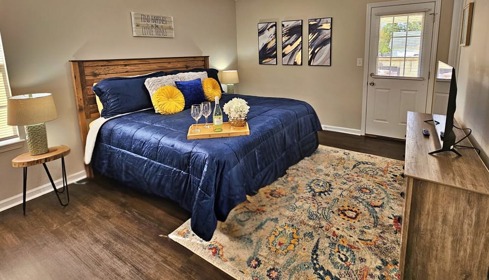 Relax in this farmhouse-style bedroom. There is a king bed along with a flat-screen smart TV. Step out the door to the back patio and fenced-in backyard.