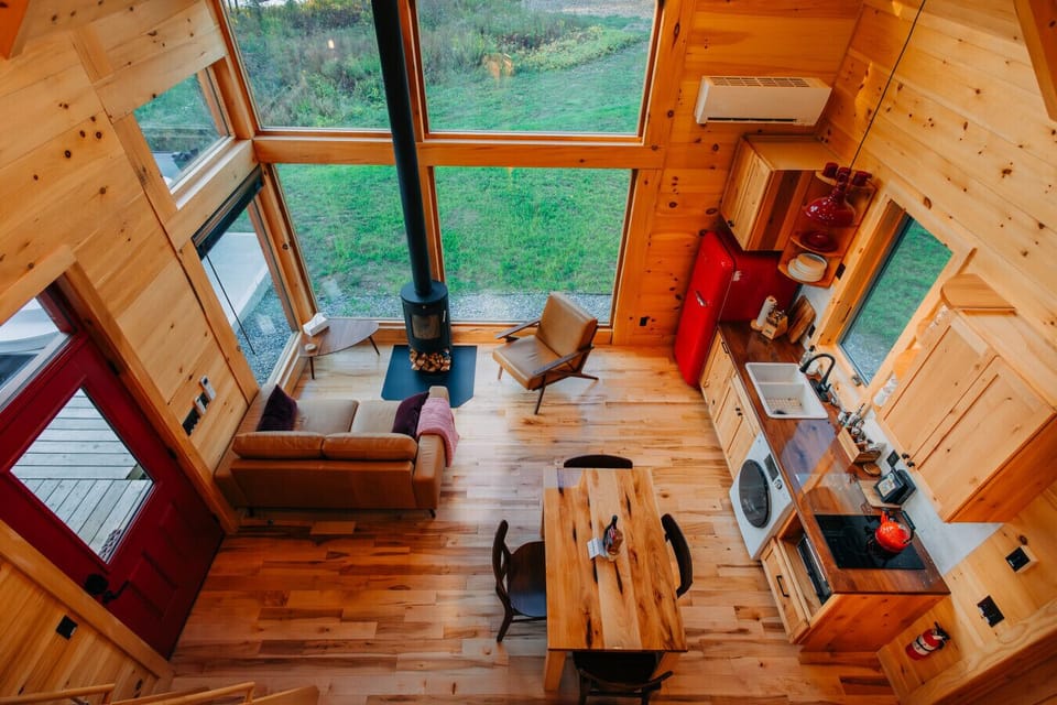View from the loft of the Cherry Cabin, showing the living area, wood stove, and kitchen.